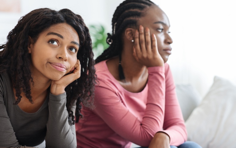 Two sad african american women sitting on a sofa