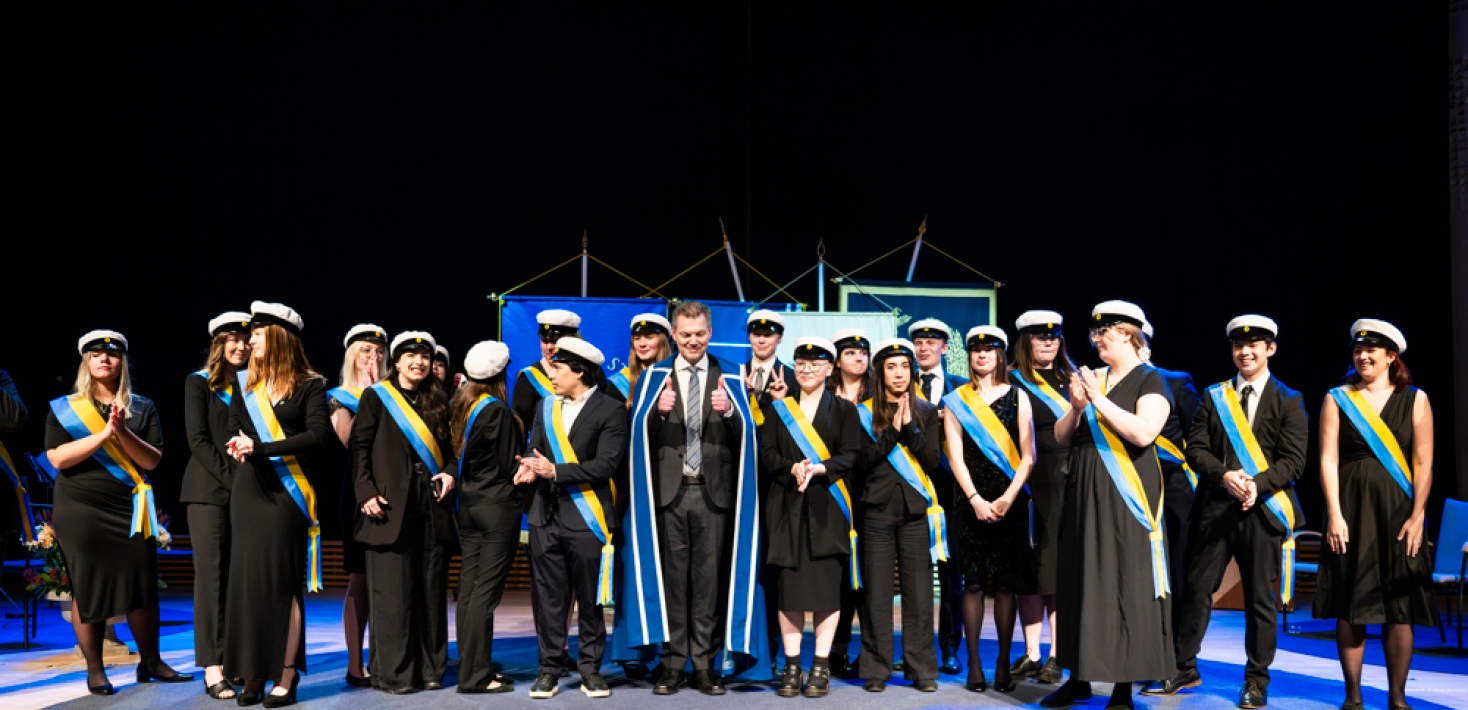Student marshals and the deputy vice-chancellor on stage in Aula Magna.