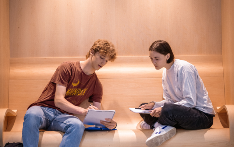 Två studenter sitter och pluggar tillsammans.