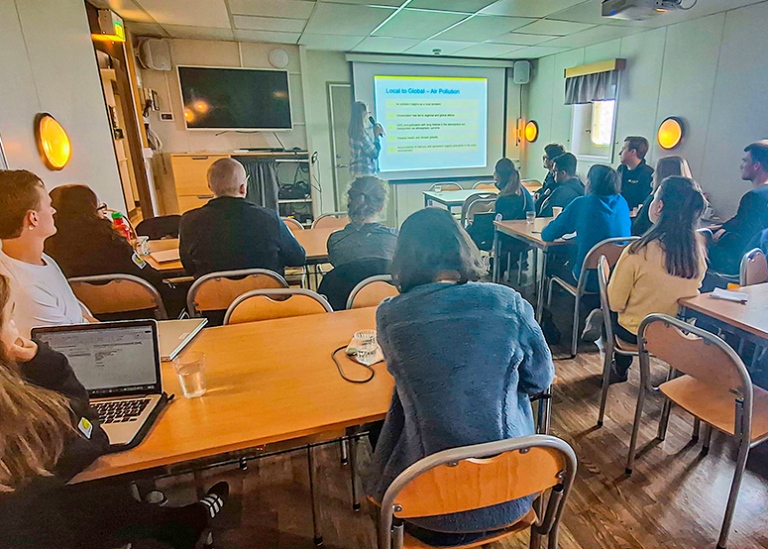 Students and lecturer in a small lecture room.