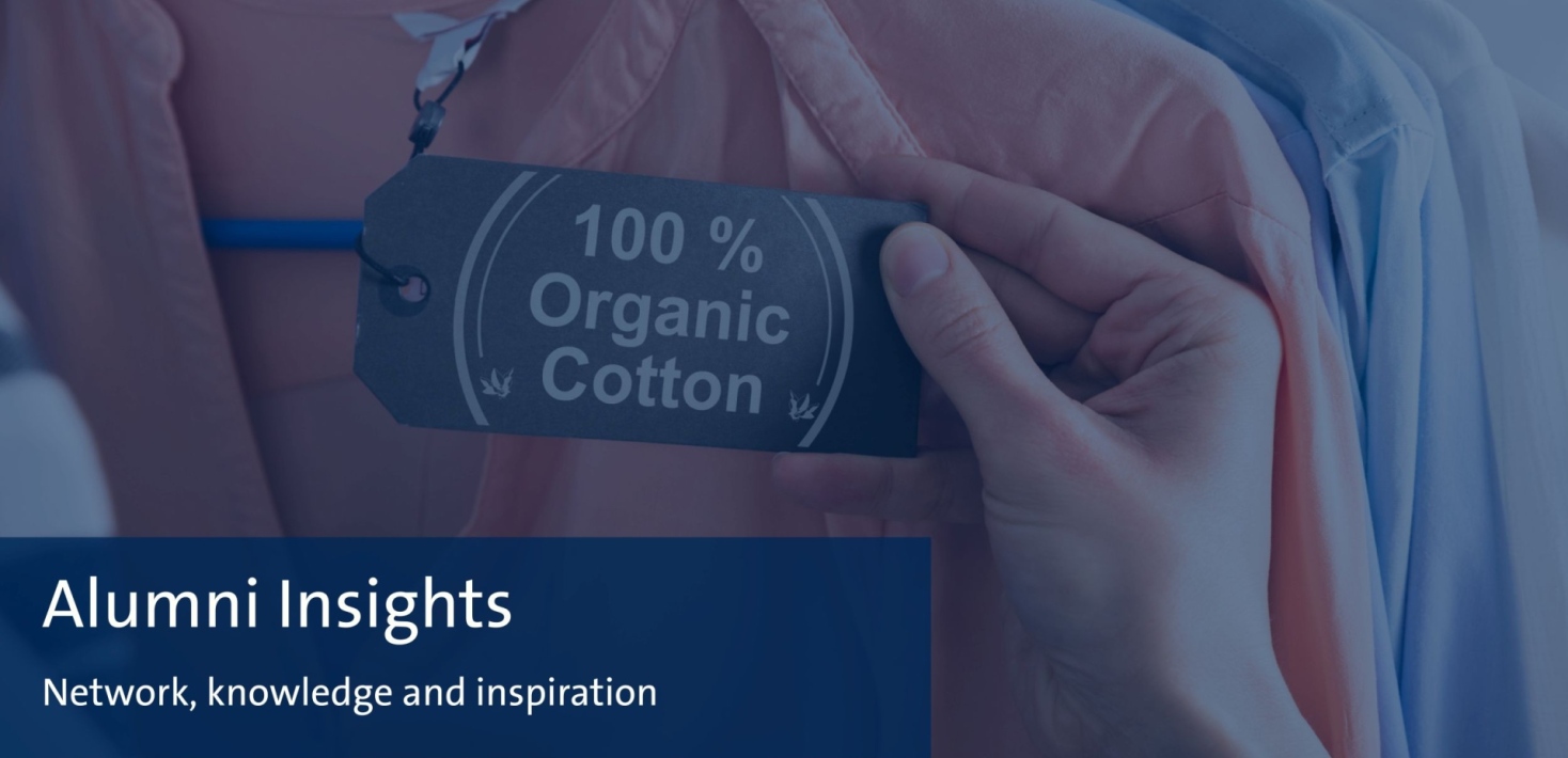 Hand holding a clothes label with the text 100 % organic cotton.