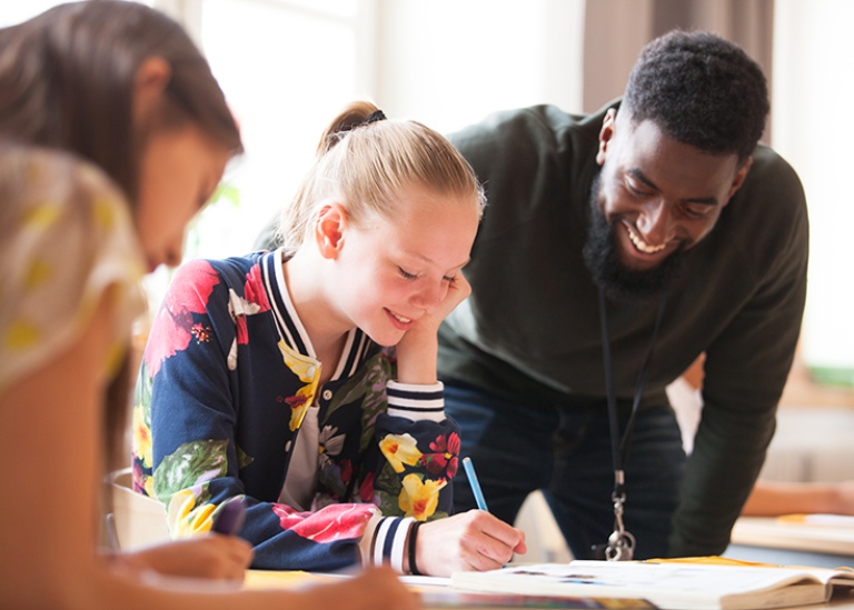 Lärarstudent tillsammans med elever i klassrummet.