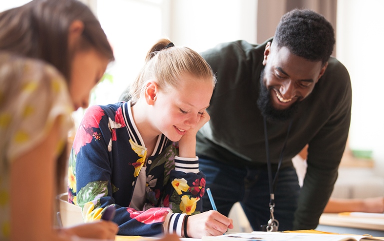 Lärarstudent tillsammans med elever i klassrummet. 