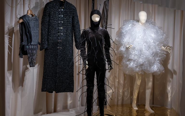 Dräkter i monter på museum.