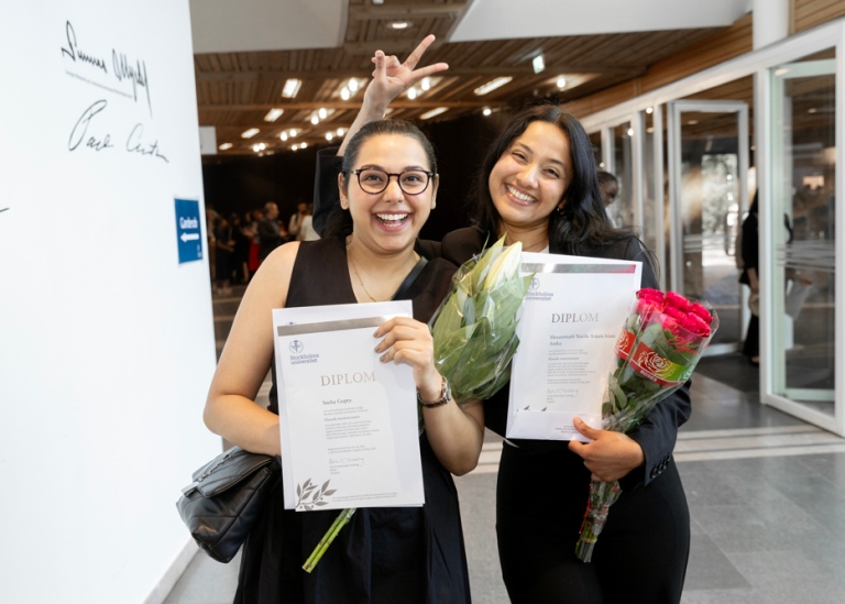 Two female master students getting their diploma, Aula magna, Stockholm University.