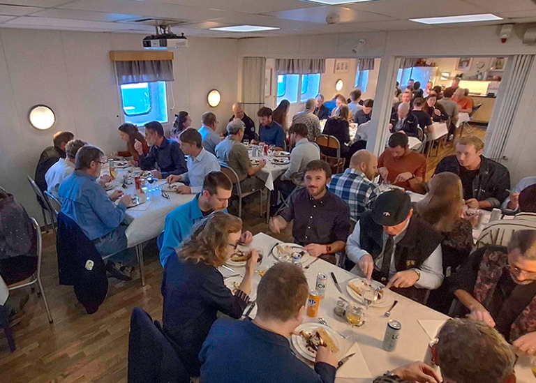 Upp till 10 nord med 6–8 personer runt varje bord som äter middag.