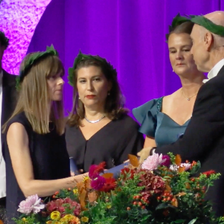 Hedvig Härnsten mottar sitt diplom av dekan Stefan Helgesson.