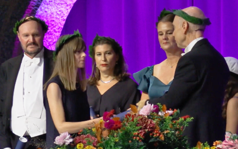 Hedvig Härnsten mottar sitt diplom av dekan Stefan Helgesson.