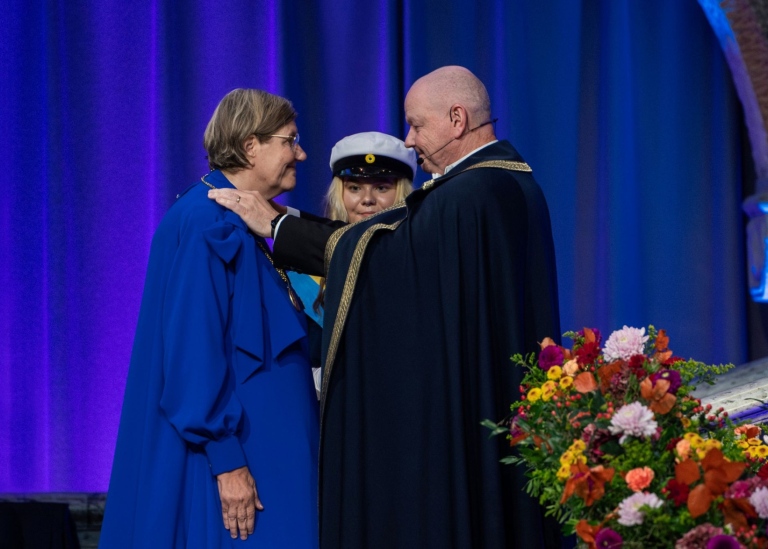 Hans Adolfsson hanging the gold medal around Astrid Söderbergh Widding's neck