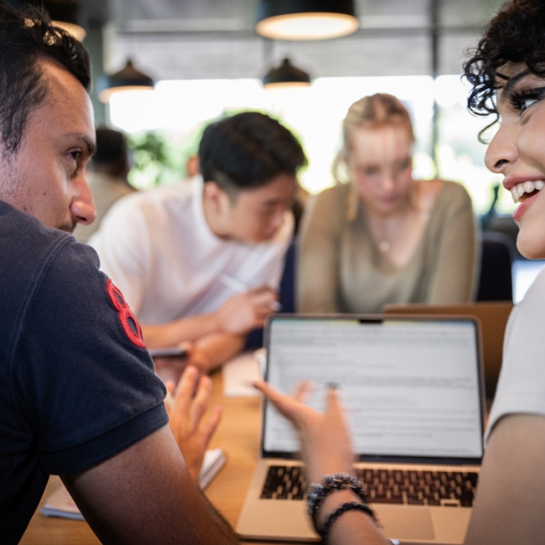 Två studenter diskuterar livligt och glatt. 
