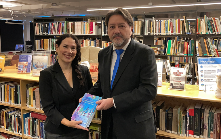 NILAS Director Thïs Machado reciving a book donation by Chiles ambassy