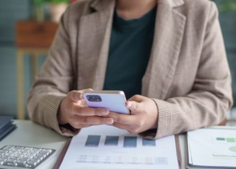 Kvinna som tittar på en mobil.