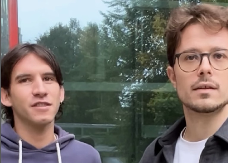 Vicent Doñate Felip and Lorenzo Luca Donati outdoors in front of a big window.