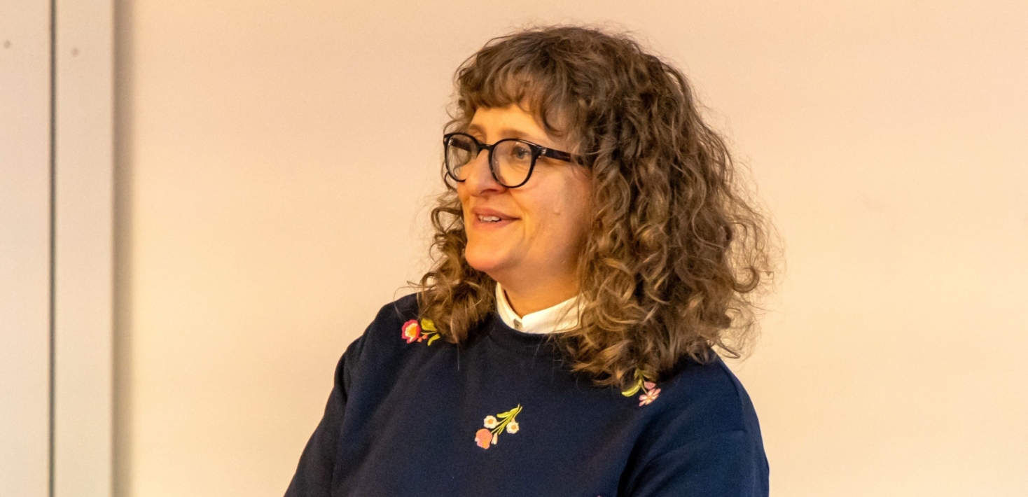 Antonia has brown, curly hair and glasses