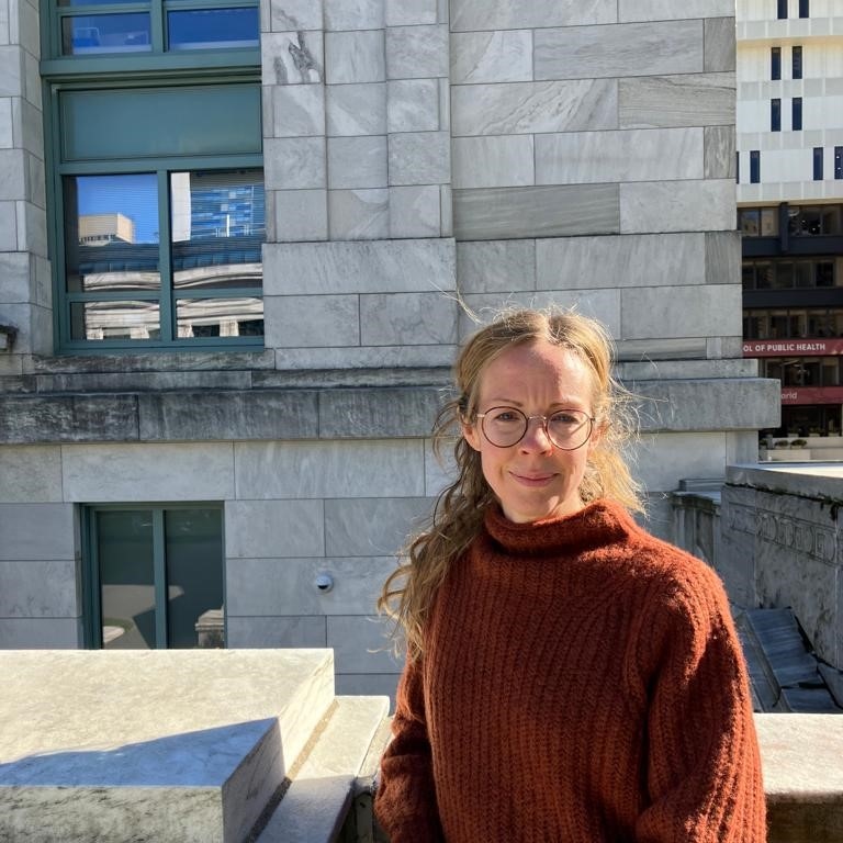 Emma Cedstrand framför en byggnad.