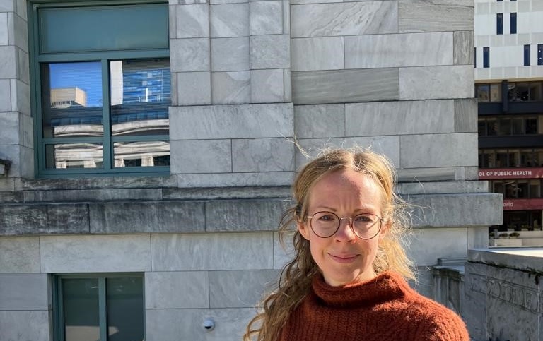 Emma Cedstrand framför en byggnad.