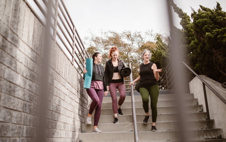 Tre tjejer i tonårsåldern som går nedför en trappa.