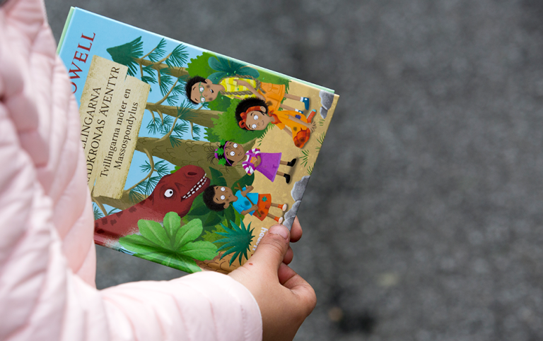 Barn håller en bok.