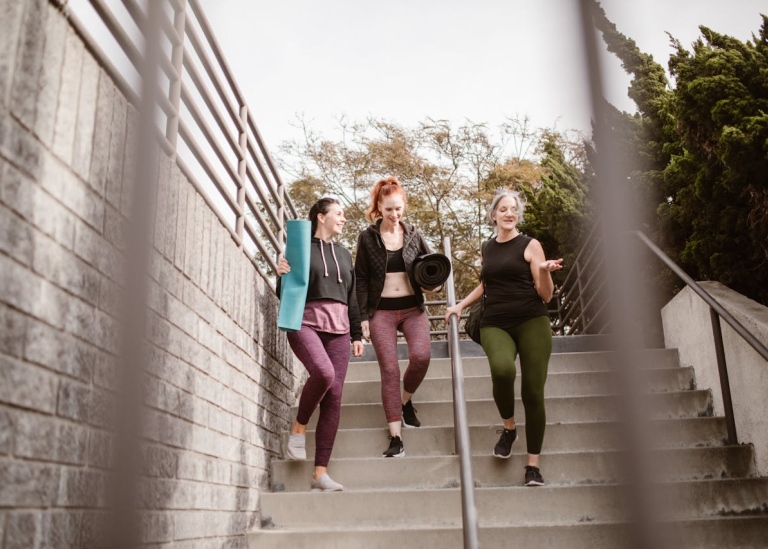 Three teenage girls walking down a staircase.