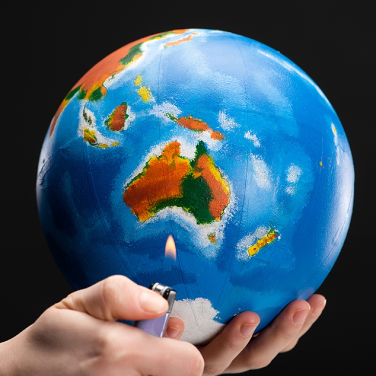 Händer håller i jordglob och cigaretttändare.