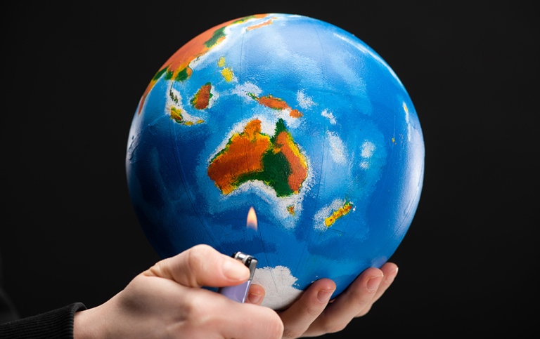 Händer håller i jordglob och cigaretttändare.