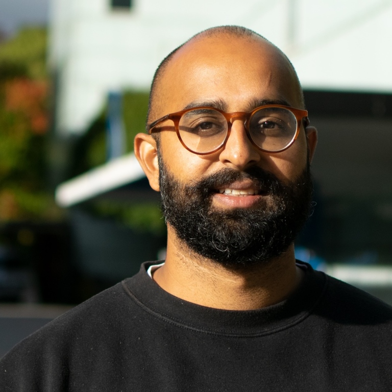 Porträttfoto på Siddartha Aradhya med campusbyggnader i bakgrunden.