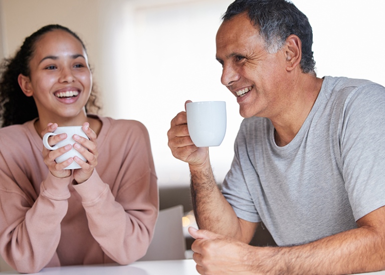 Ung kvinnlig vuxen fikar med en man, förmodligen en far.