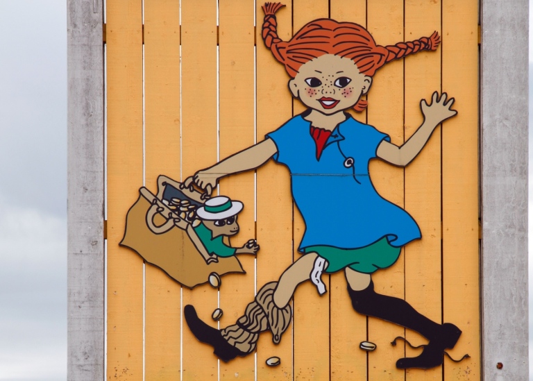 Pippi Långstrump avbildad på ett gult träplank.