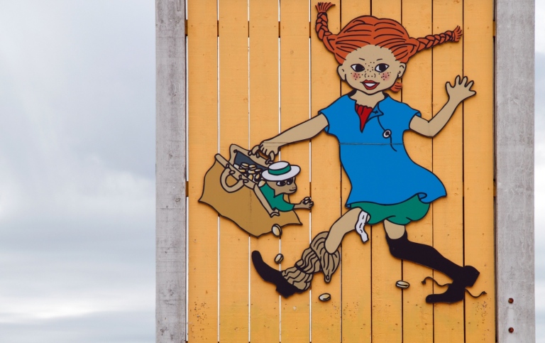 Pippi Långstrump avbildad på ett gult träplank.